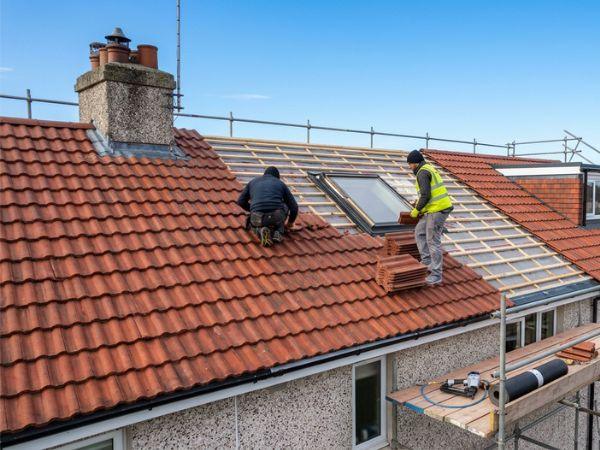 Roofers fitting a new tile roof